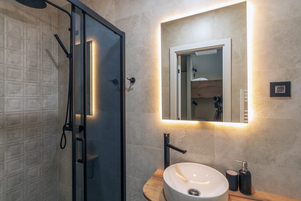 Bathroom of room N3 with a shower, a backlit mirror and a round basin