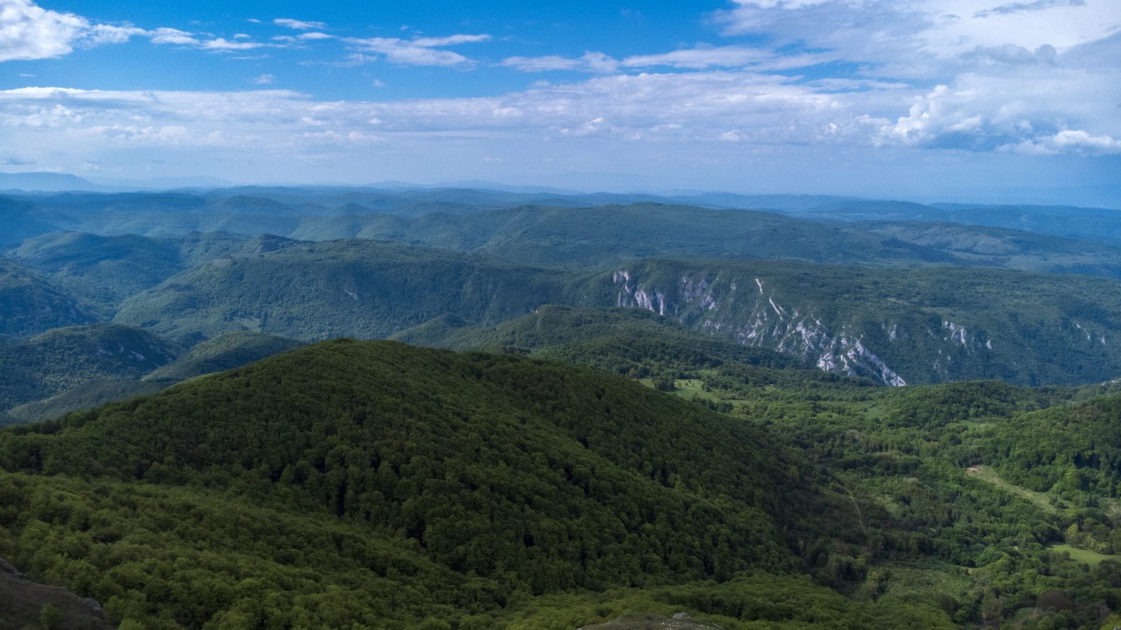 Šumoviti grebeni i krečnjačke litice iznad doline, snimljeno iz vazduha
